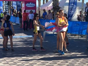 Llegada de Natacha López a meta recibida por las atletas que han subido al podio